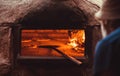 Cooker puts pizza the oven for baking. traditional italian restaurant with tasty pizza Royalty Free Stock Photo