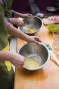 Cookery scene with female hands beating eggs with eggbeater in m