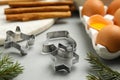 Cookie cutters and eggs on light grey table, closeup. Christmas biscuits Royalty Free Stock Photo