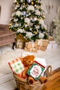 Cookie with deers and numbers 2019 in carton box on a teddy bear in a wicker basket in front of defocused lights of Christmas deco