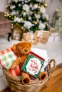 Cookie with deers and numbers 2019 in carton box on a teddy bear in a wicker basket in front of defocused lights of Christmas deco