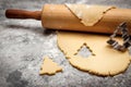 Cookie dough and rolling pin on grey table, christmas tree shaped cutter Royalty Free Stock Photo