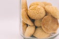 Cookie jar, simple glass jar filled with old fashioned cookies on off white background