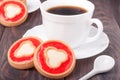 Cookie with jelly and cup of coffee on wooden table Royalty Free Stock Photo