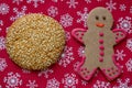 Cookie with sesame on red Christmas background with snowflakes Royalty Free Stock Photo
