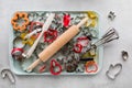 A cookie sheet filled with cookie cutters and other various baking tools.