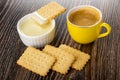 Cookie on small bowl with condensed milk, yellow cup with coffee, cookies on wooden table