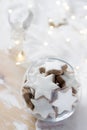 Cookies Cinnamon star in a glass vase on a white background decorated with a figurine of an angel and a garland. Royalty Free Stock Photo