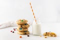 Cookies with colorful candies and chocolate chips and a bottle of milk on white background. Side view, copy space. Multicolor Royalty Free Stock Photo