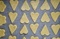 The cookies are cut from a heart-shaped dough and laid on a sheet of craft paper for baking