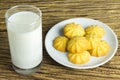 Cookies in dish with a glass of cold milk on wooden background