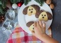 Cookies in the form of a dog on the Christmas table. Symbol of the new year 2018. A child takes a cookie Royalty Free Stock Photo