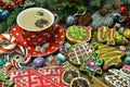 Cookies, knitted mittens, candy and cup with saucer on festive table