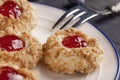 Cookies made from hazelnut shortcake with strawberry jam inside on a white plate with a patterned dessert fork Royalty Free Stock Photo