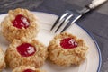 Cookies made from hazelnut shortcake with strawberry jam inside on a white plate with a patterned dessert fork Royalty Free Stock Photo