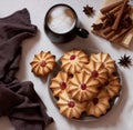 Cookies on a platter, next to a cup of coffee, textiles, spices, star anise and cinnamon sticks. Royalty Free Stock Photo