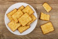 Cookies with sesame in plate, broken cracker on wooden table. Top view