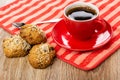 Cookies with sesame, raisin, coffee in cup on saucer, spoon on n
