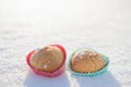 Cookies in the shape of hearts in the snow.