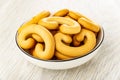 Cookies in shape pretzels in bowl on wooden table Royalty Free Stock Photo