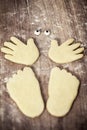 Cookies shaping a figure with hands, feets and eyes on wooden table