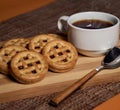 Cookies stuffed with nutella and hot coffee in a wood tone