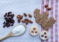 Cookies on a tablecloth with almonds, raisins and flour Royalty Free Stock Photo