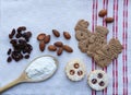 Cookies on a tablecloth with almonds, raisins and flour