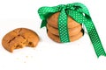 Cookies tied with green ribbon and bitten cookie with crumbs, on white background. Royalty Free Stock Photo