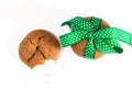 Cookies tied with green ribbon and bitten cookie with crumbs, on white background. Royalty Free Stock Photo