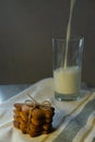 Cookies on towel and milk in glass on windowsill