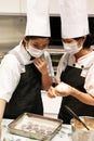 Beijing China - June 10, 2018:Two chefs lay out cookie dough on an iron baking tray.