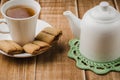 Cookies, white cup of tea and teapot on a wooden background/cookies, white cup of tea and teapot on a wooden background. selective Royalty Free Stock Photo