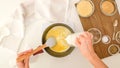 Cooking Alfredo sauce for asparagus casserole. Chef adds milk in saucepan Royalty Free Stock Photo