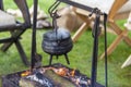 Rusty old cooking pot simmering over open fire at a campsite. Royalty Free Stock Photo