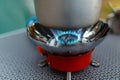 Cooking in an aluminum pot meals on a portable gas burner on a background of camping in the woods. Close-up of portable gas burner Royalty Free Stock Photo