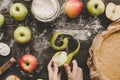 Cooking apple pie. Hands peeling apples for apple pie on the wooden table. Top view Royalty Free Stock Photo