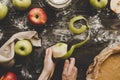 Cooking apple pie. Hands peeling apples for apple pie on the wooden table. Top view Royalty Free Stock Photo