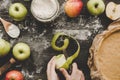 Cooking apple pie. Hands peeling apples for apple pie on the wooden table. Top view Royalty Free Stock Photo