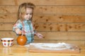 Cooking baby. Kid boy cooks in the kitchen. Little boy puts the dough in a baking dish playing with flour.