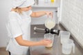 Cooking, baking and people concept. Young woman, professional confectioner, working in the kitchen, preparing the sauce