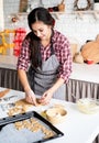 Young brunette woman baking cookies at the kitchen