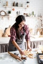 Young brunette woman baking cookies at the kitchen