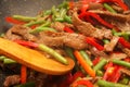 Cooking beef, capsicum and bean stirfry in wok