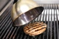 Cooking a beef hamburger patty on a grill