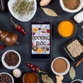 Cooking blog concept. Indian spices, herbs and smartphone on black