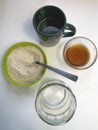 Cooking bread sourdough at home. On the table are the ingredients. Flour, honey and water Royalty Free Stock Photo