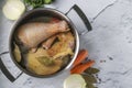 Cooking broth from homemade chicken with pepper and bay leaf in a pan on a marble background. Healthy eating concept. Horizontal