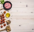 Cooking burgers, ground beef with herbs and cherry tomatoes on a branch border ,place for text wooden rustic background top vi