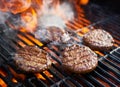 Cooking burgers on hot grill with flames